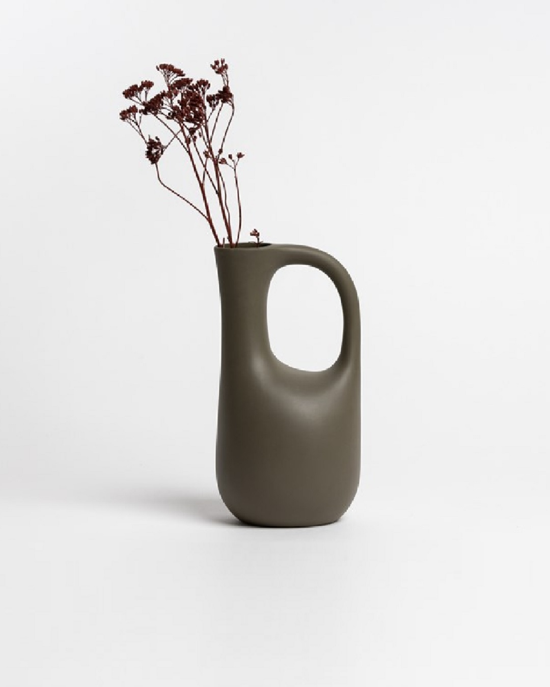 Olive jug with flowers in it