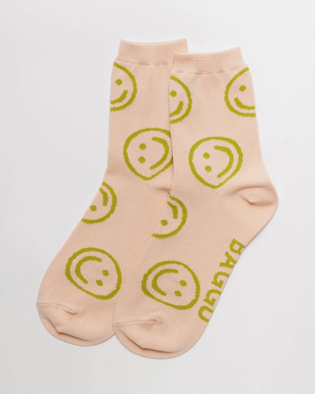 Light pink with green smiley faces pair of socks