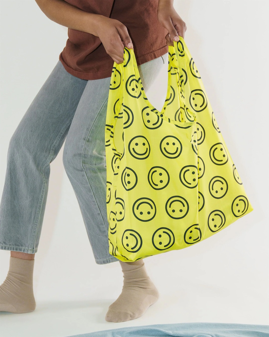 Yellow smiley face bag being carried
