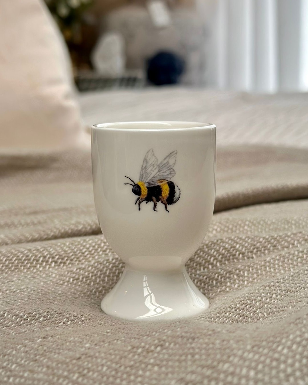 White egg cup with bumble bees on it
