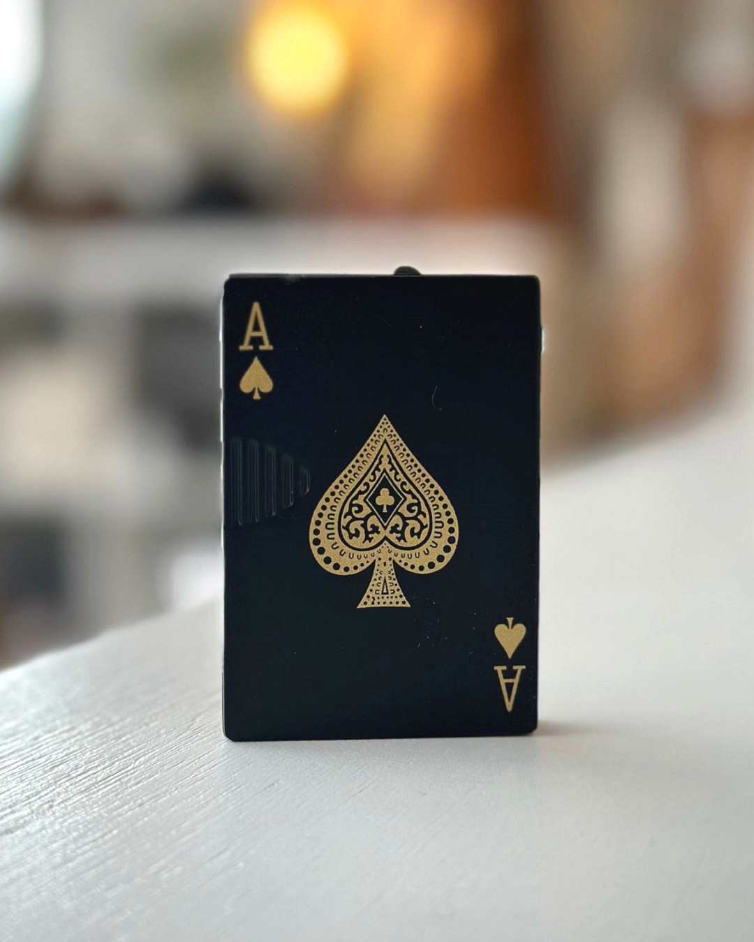 Black Ace of cards lighter on table
