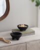 Black teak bowls with feet on shelf with nuts in one bowl