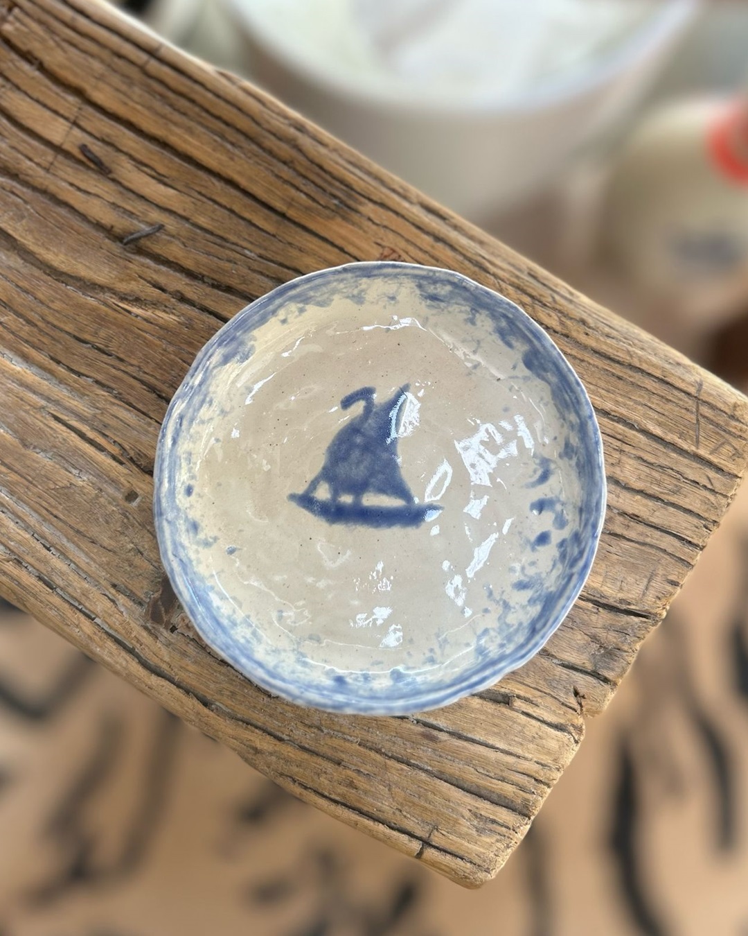 Plate with boat image in blue on it on wooden table