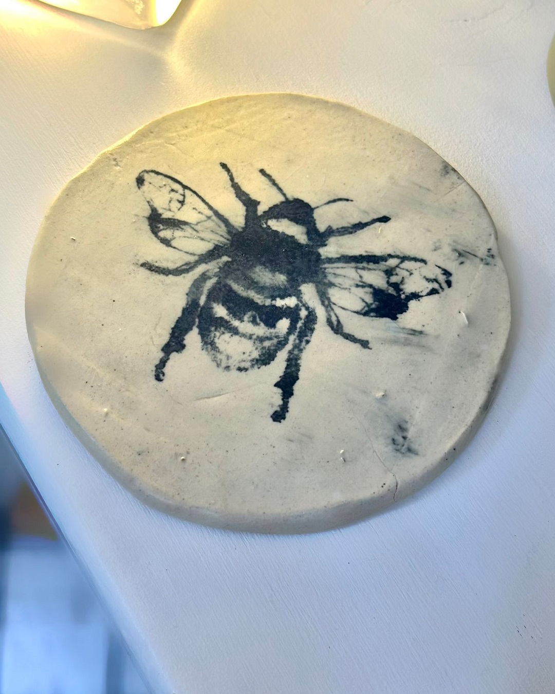 Circle plaque with bumble bee print on it