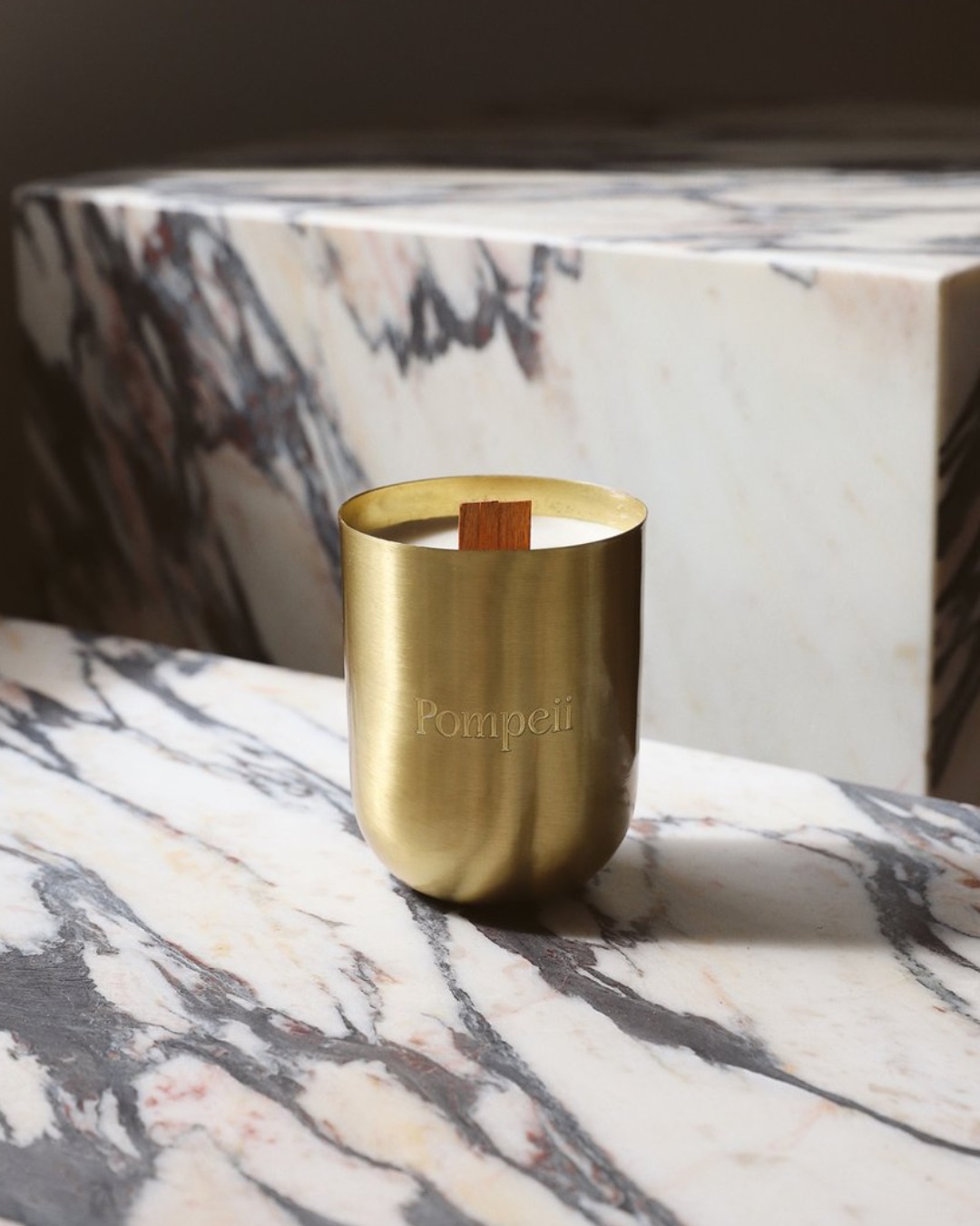 Burning brass candle on marble table