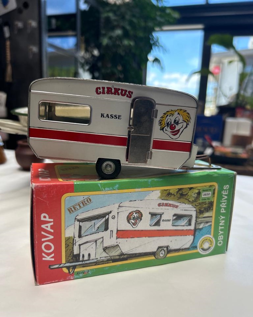 Collectable tin circus caravan toy on box on shelf