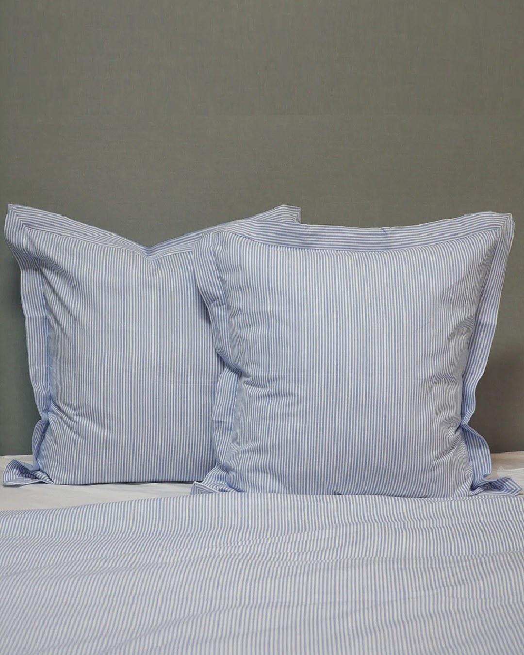 Blue stripe euro pillows on bed