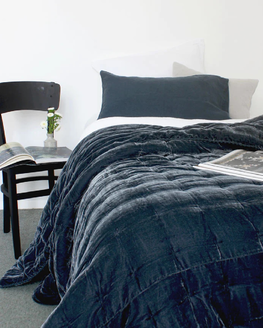 Blue velvet comforter on white bed