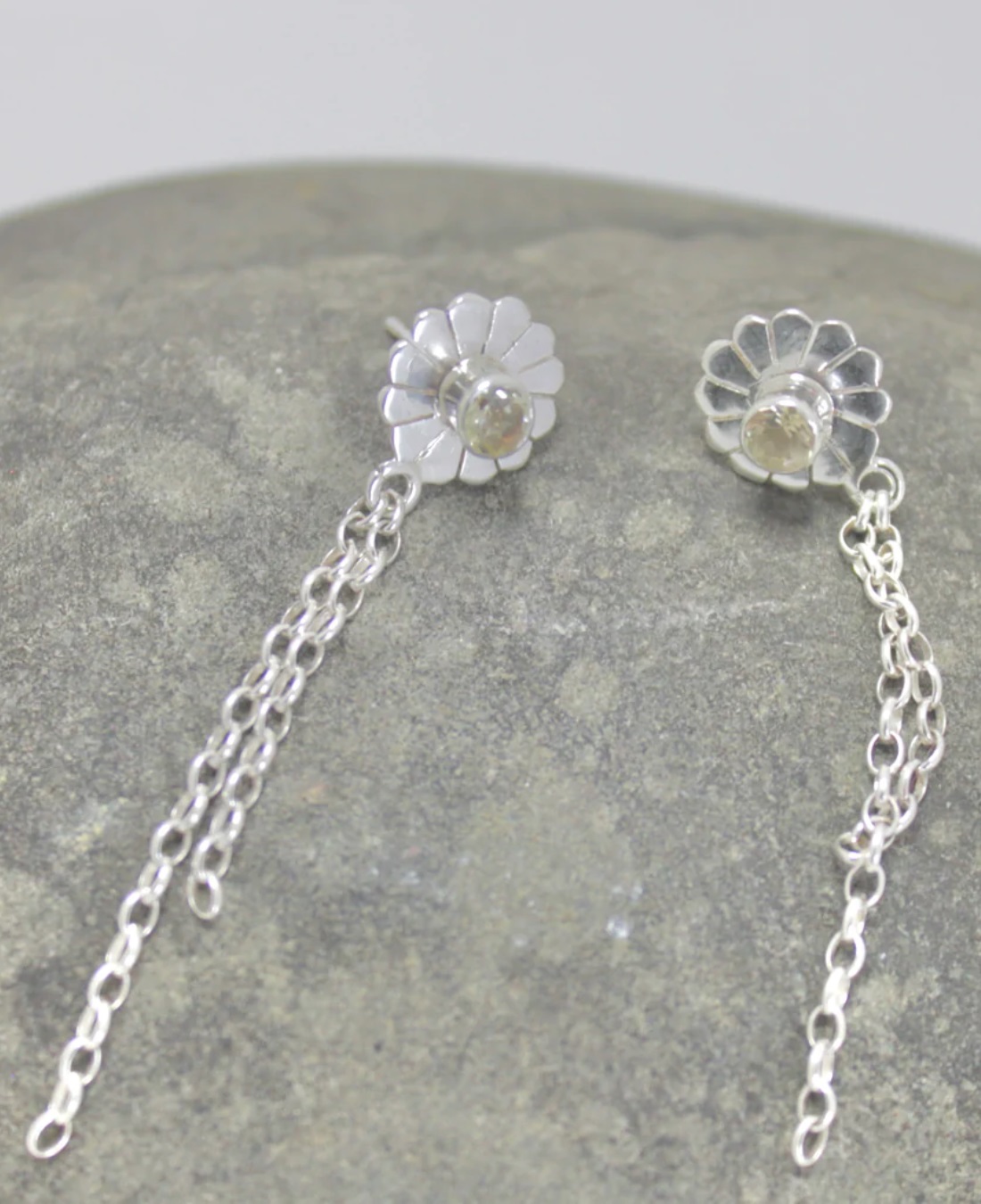 Daisy chain silver earrings on rock
