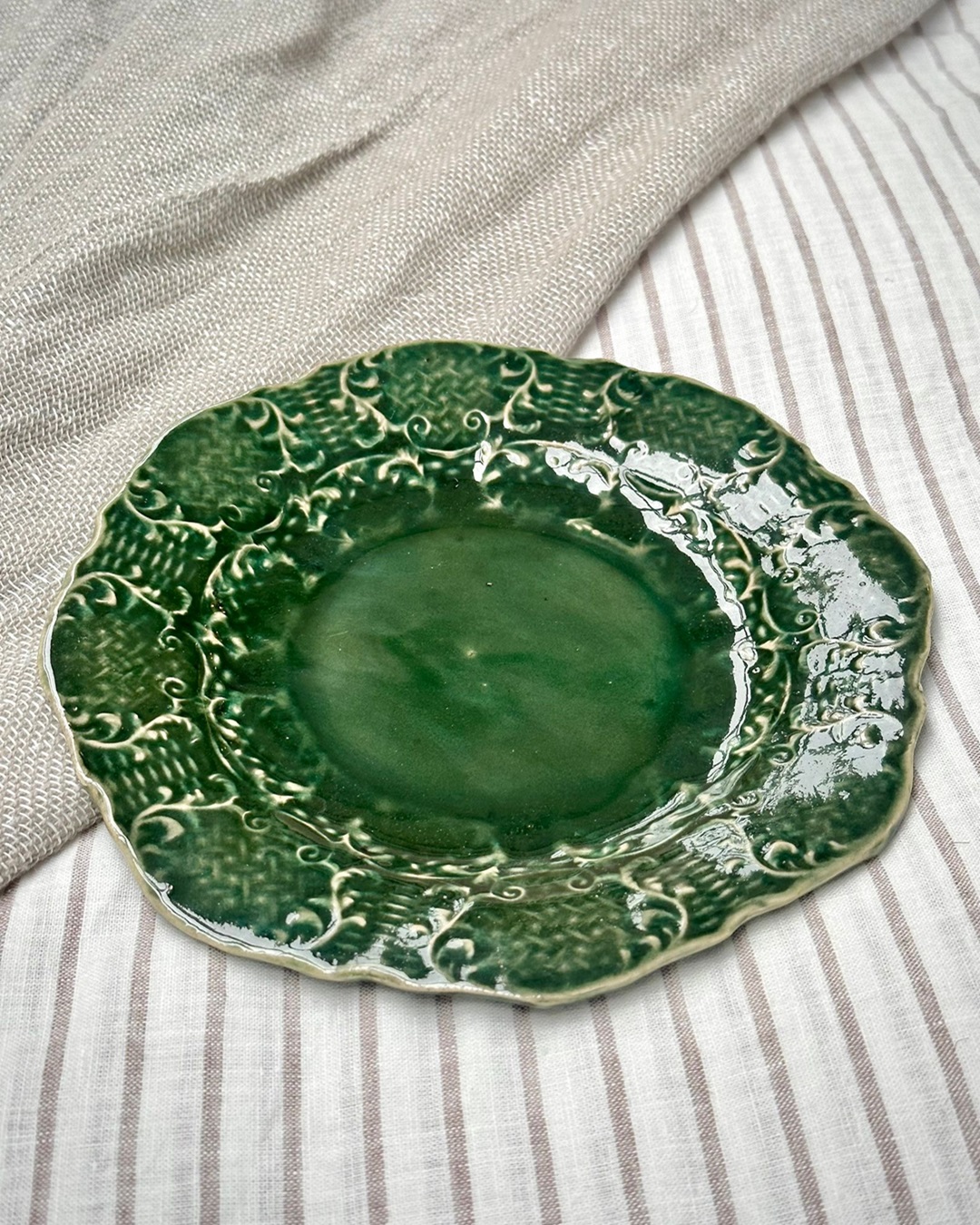 Dark green decorative plate on bed