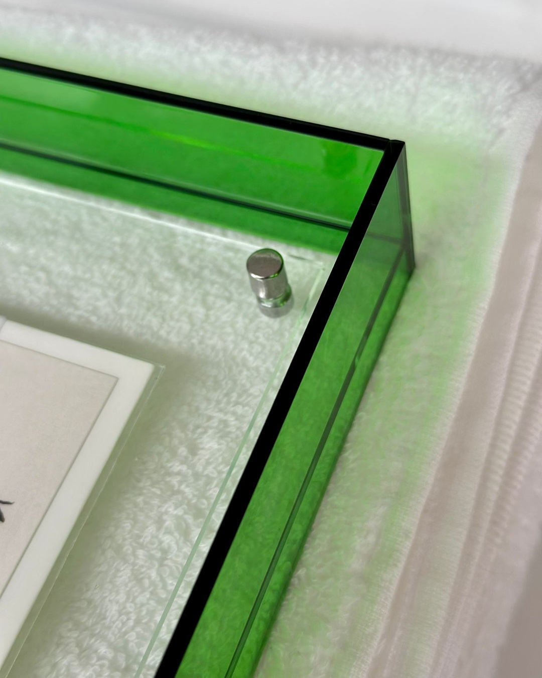 Green and clear frame corner on white towel