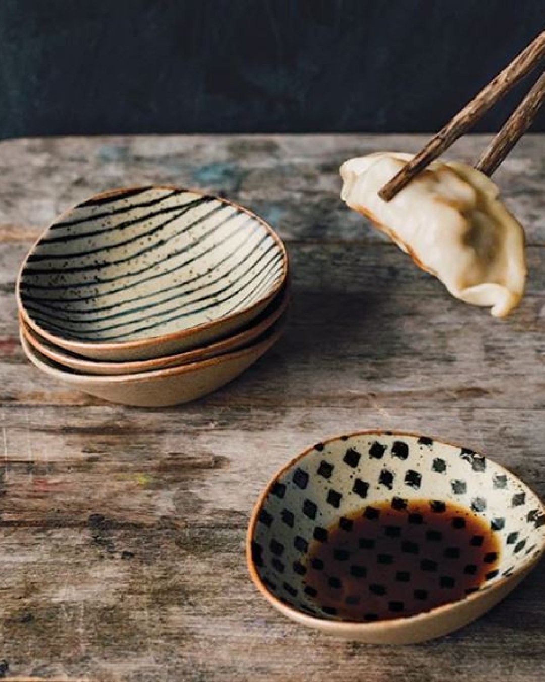 Dipping dishes with dumpling and chopsticks