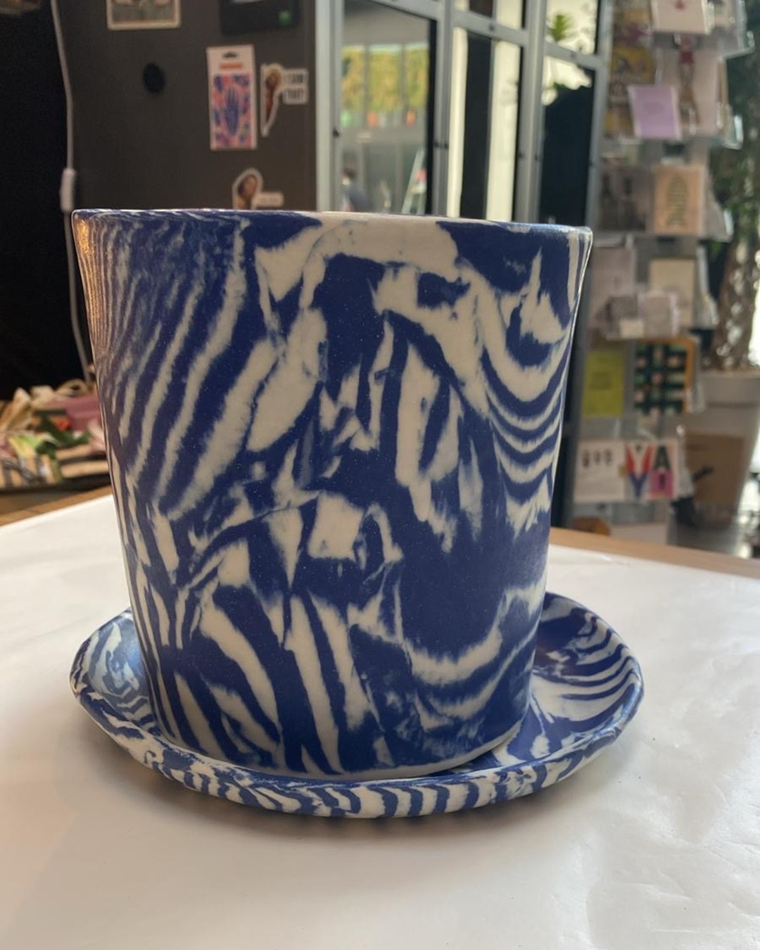 Blue planter with saucer on table