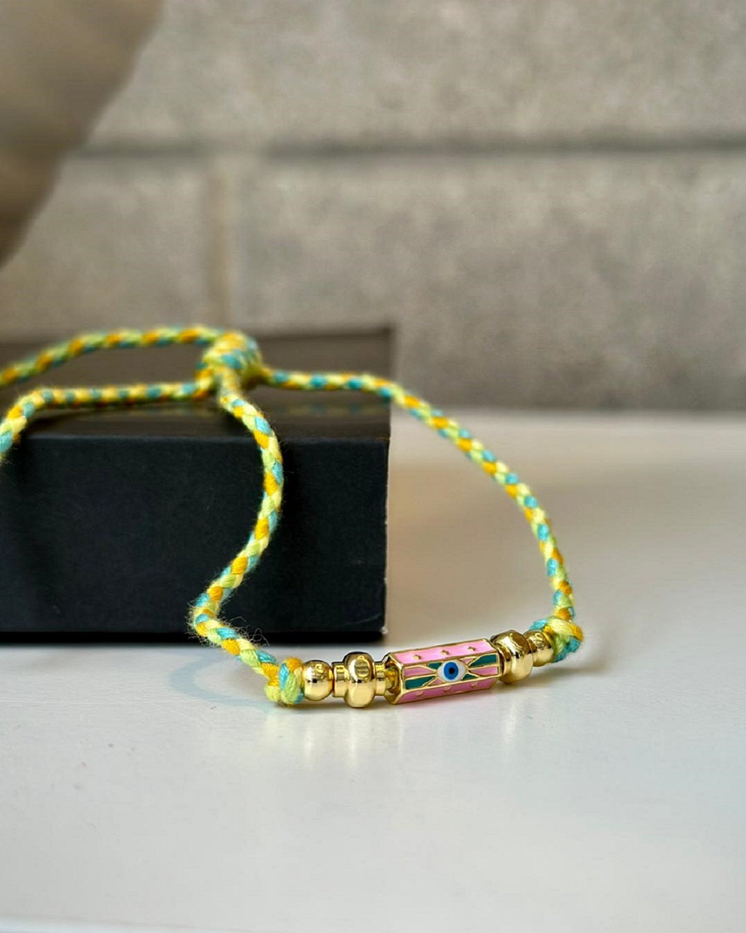 Woven yellow green and orange bracelet with eye charm