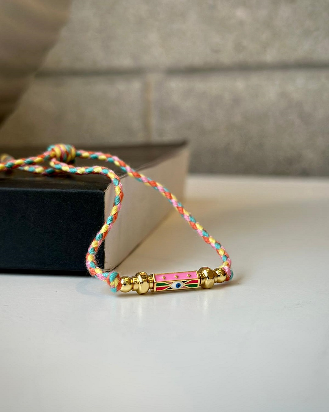 Woven yellow pink and orange bracelet with eye charm