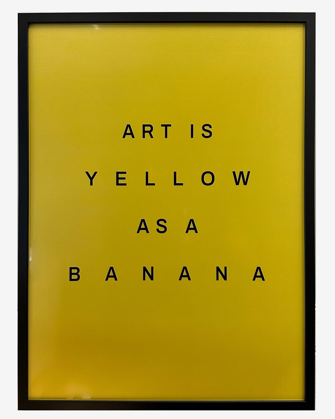 Yellow framed art that says art is yellow as a banana