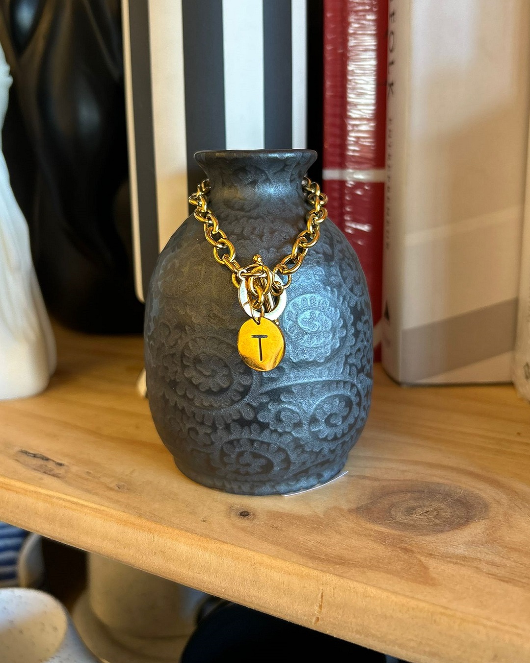 Golda charm bracelet hanging on a vase