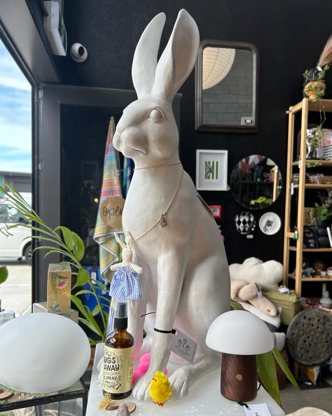 Harold the hare white statue on table with other items around him