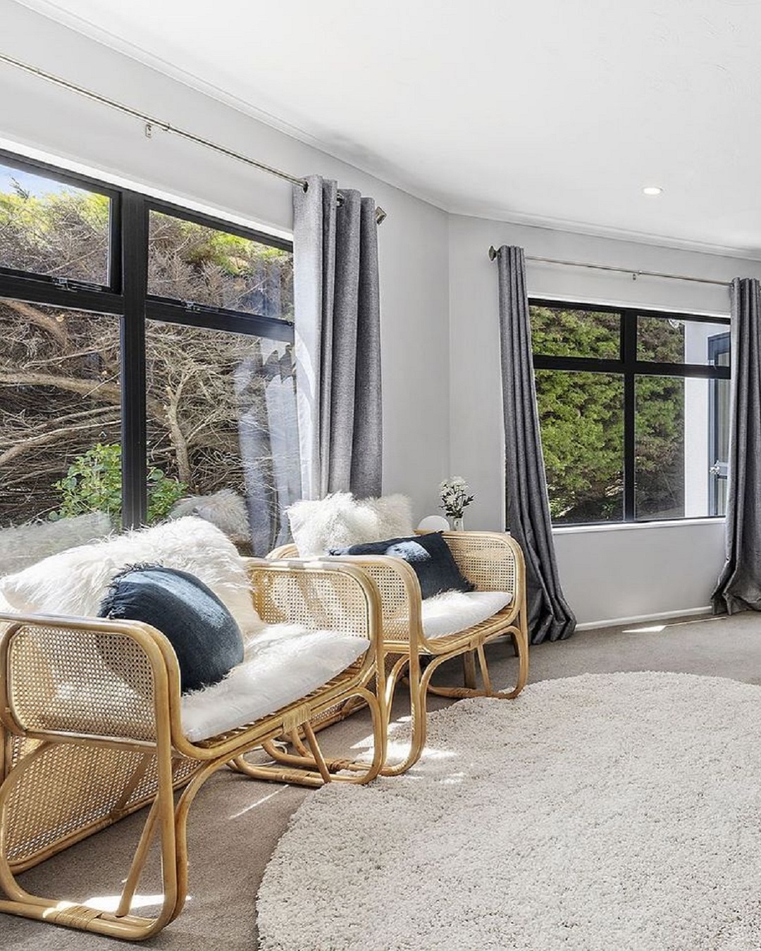 Cane chairs with white cushions in lounge