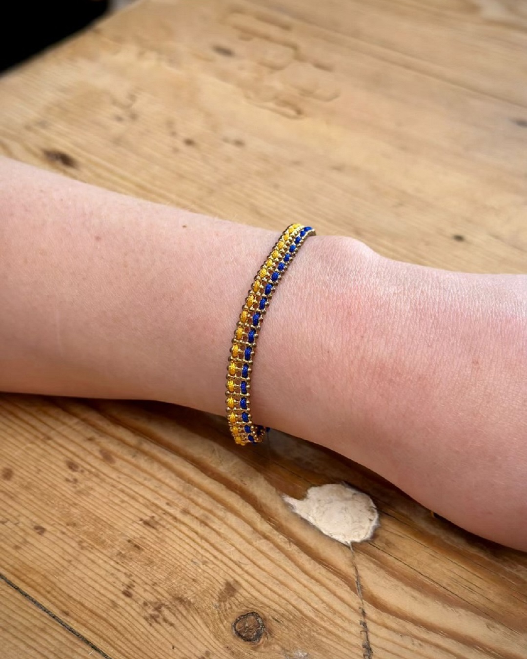 knitted blue and yellow bracelet on wrist