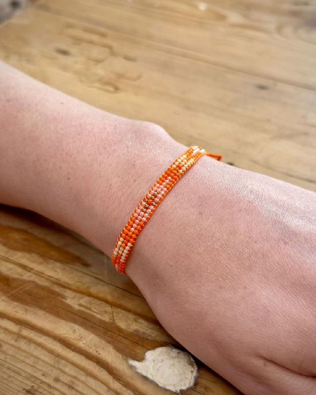 knitted pink and orange bracelet on wrist
