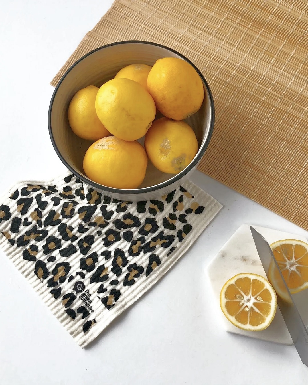 Leopard print dish cloth on bench with bowl and oranges