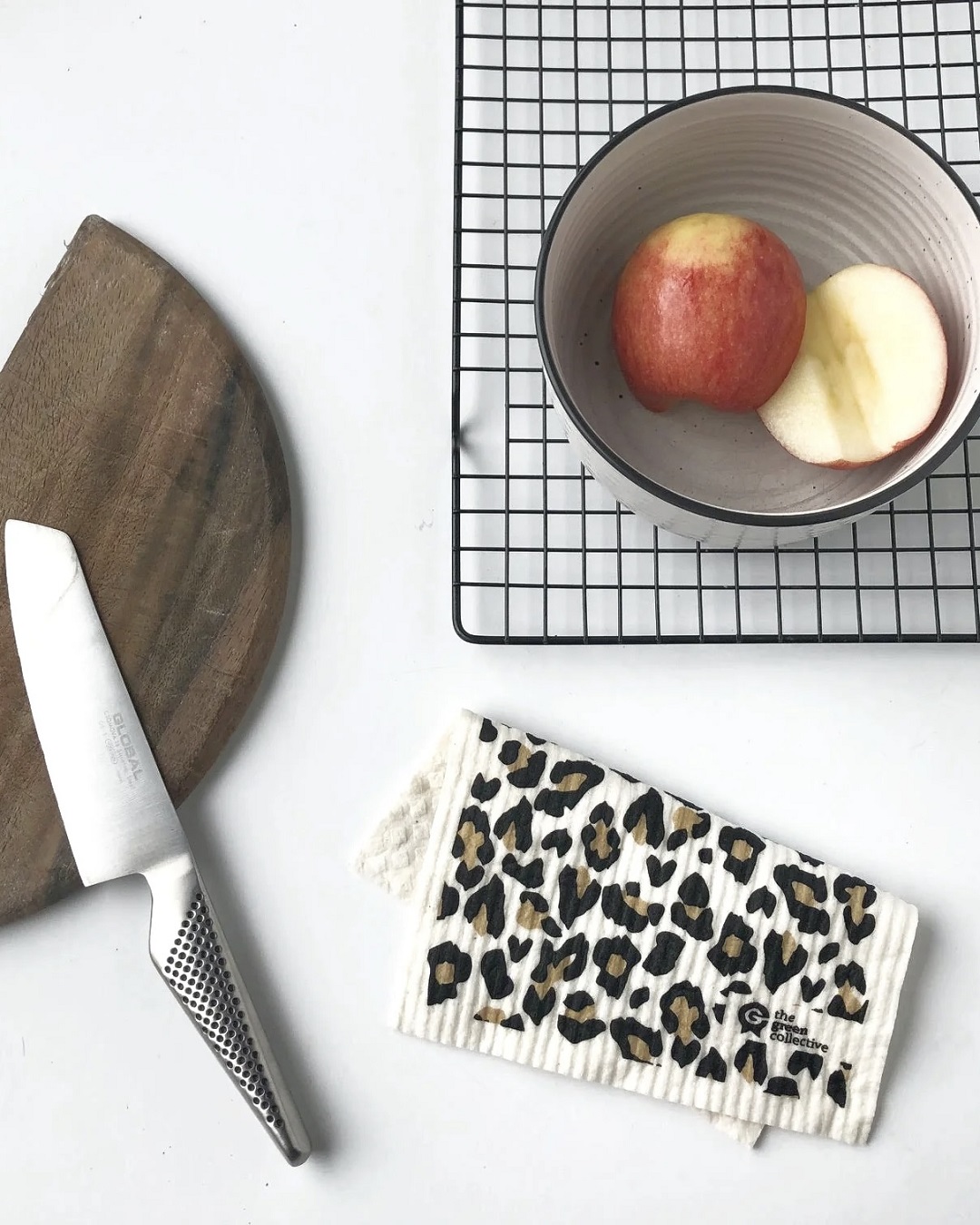 Leopard dish cloth on bench with fruit bowl and board with knife