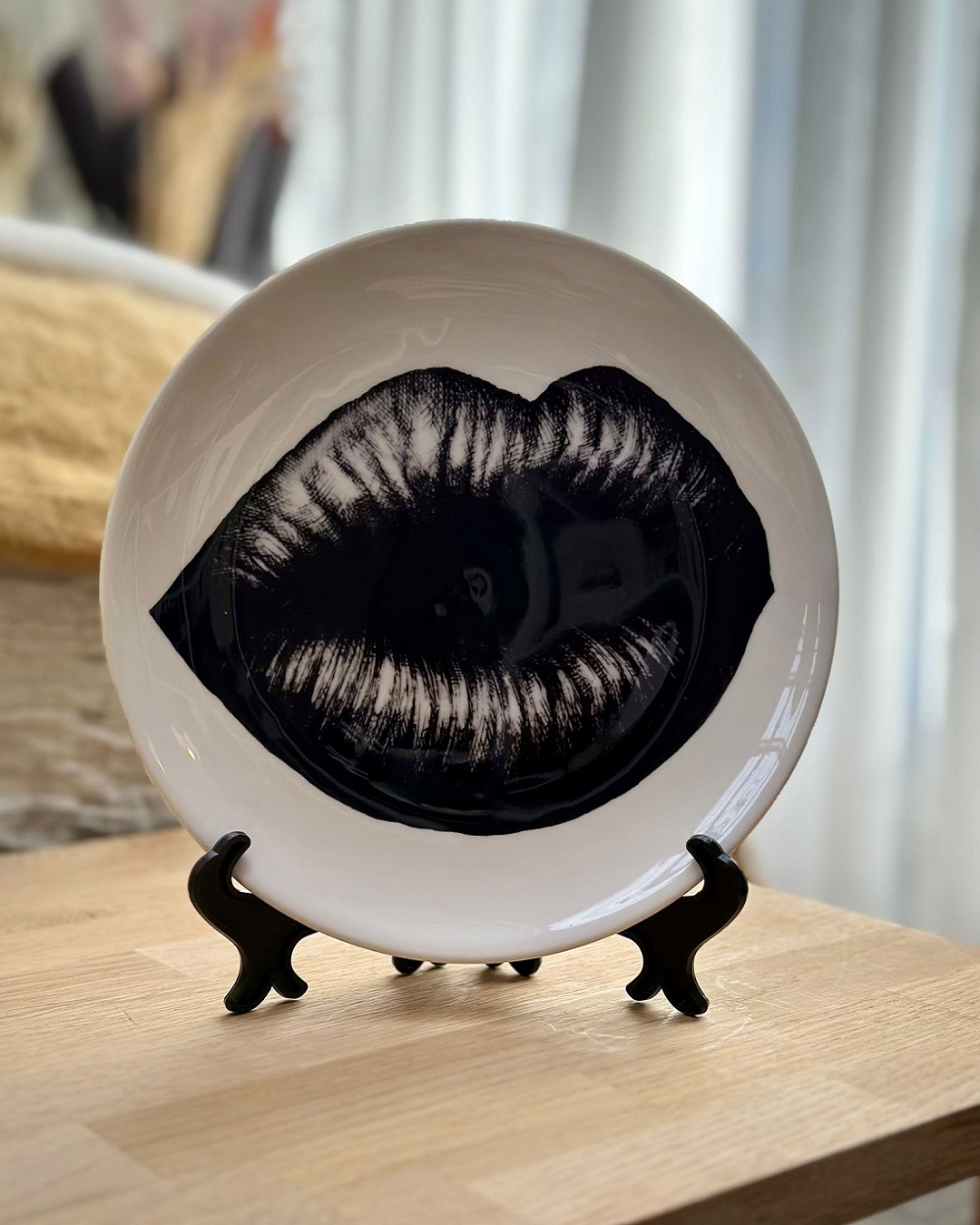 Round white plate in plate stand with black lips on it
