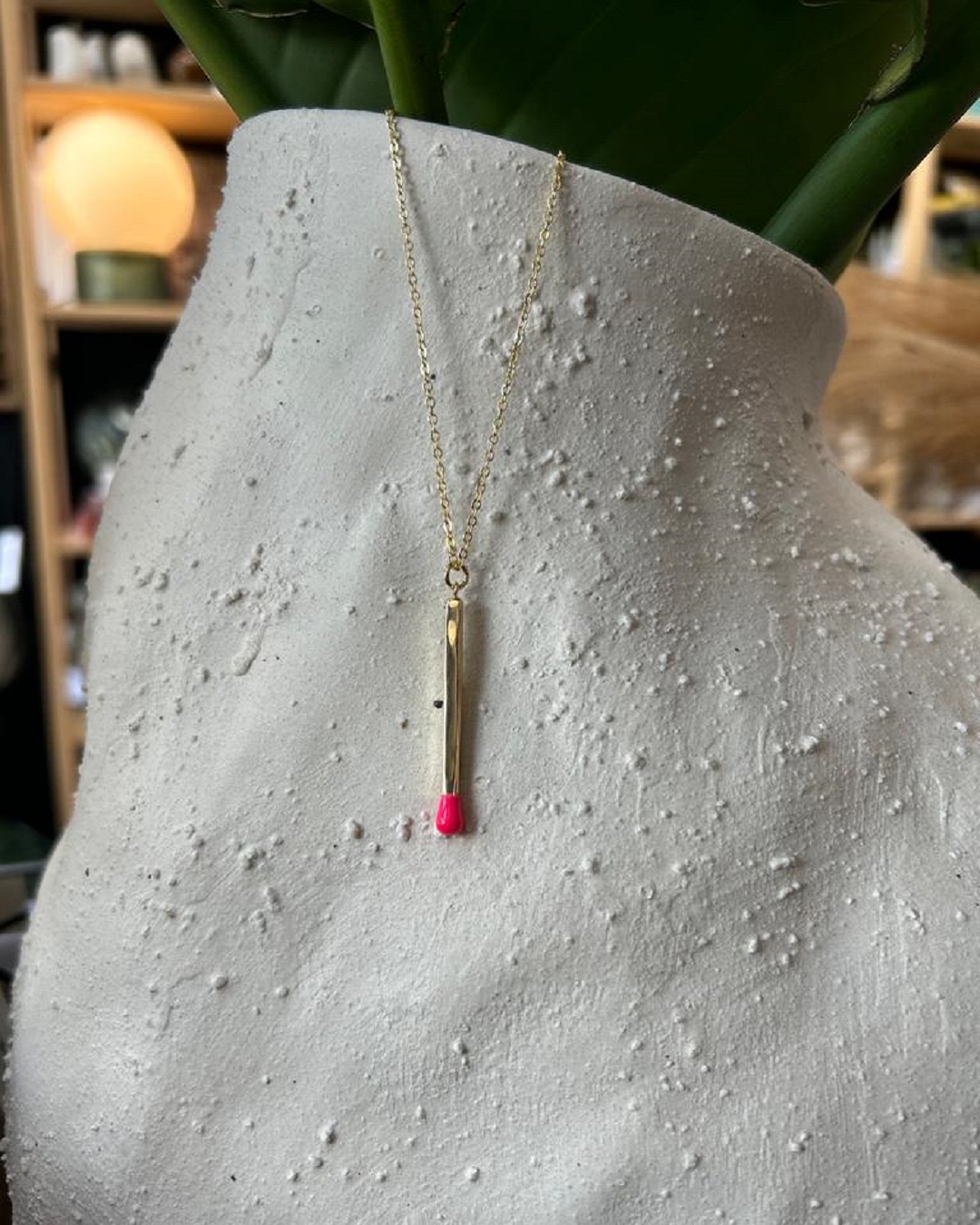 Matchstick necklace hanging on vase