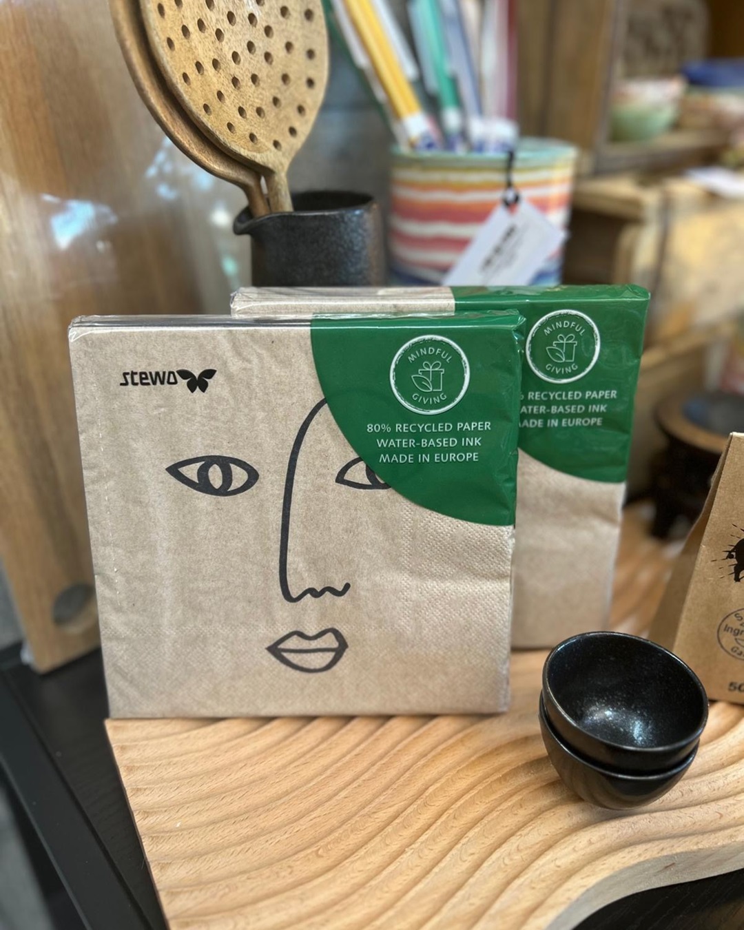 Beige napkins in a packet with black ardik face