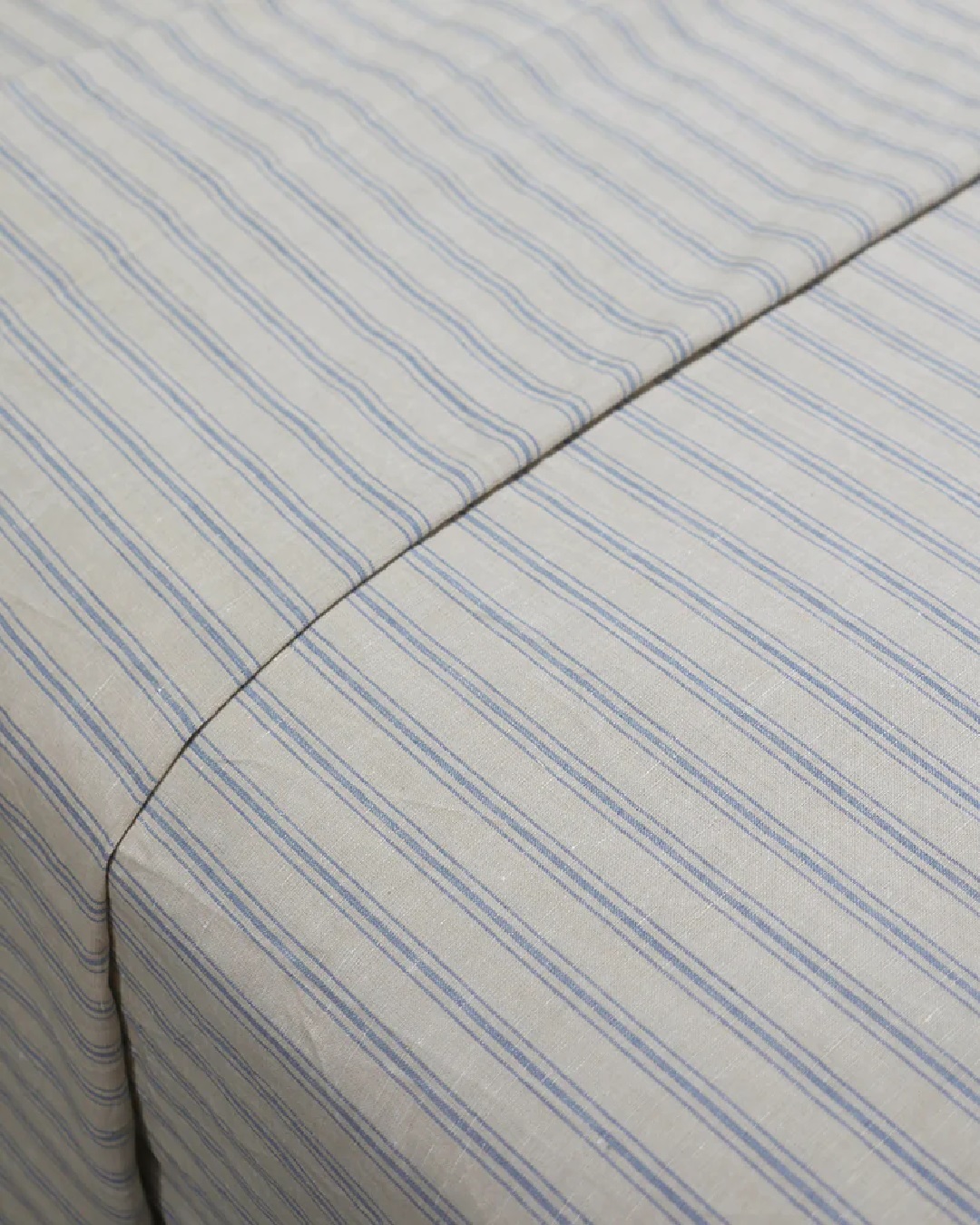 Striped blue and white sheets on bed