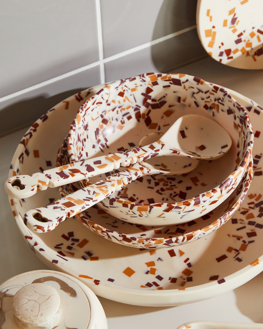 Red and orange terrazzo salad servers in bowls