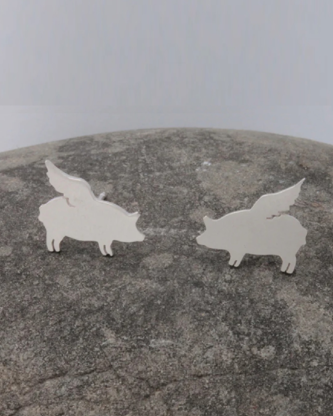 Silver stud earrings of pigs with wings