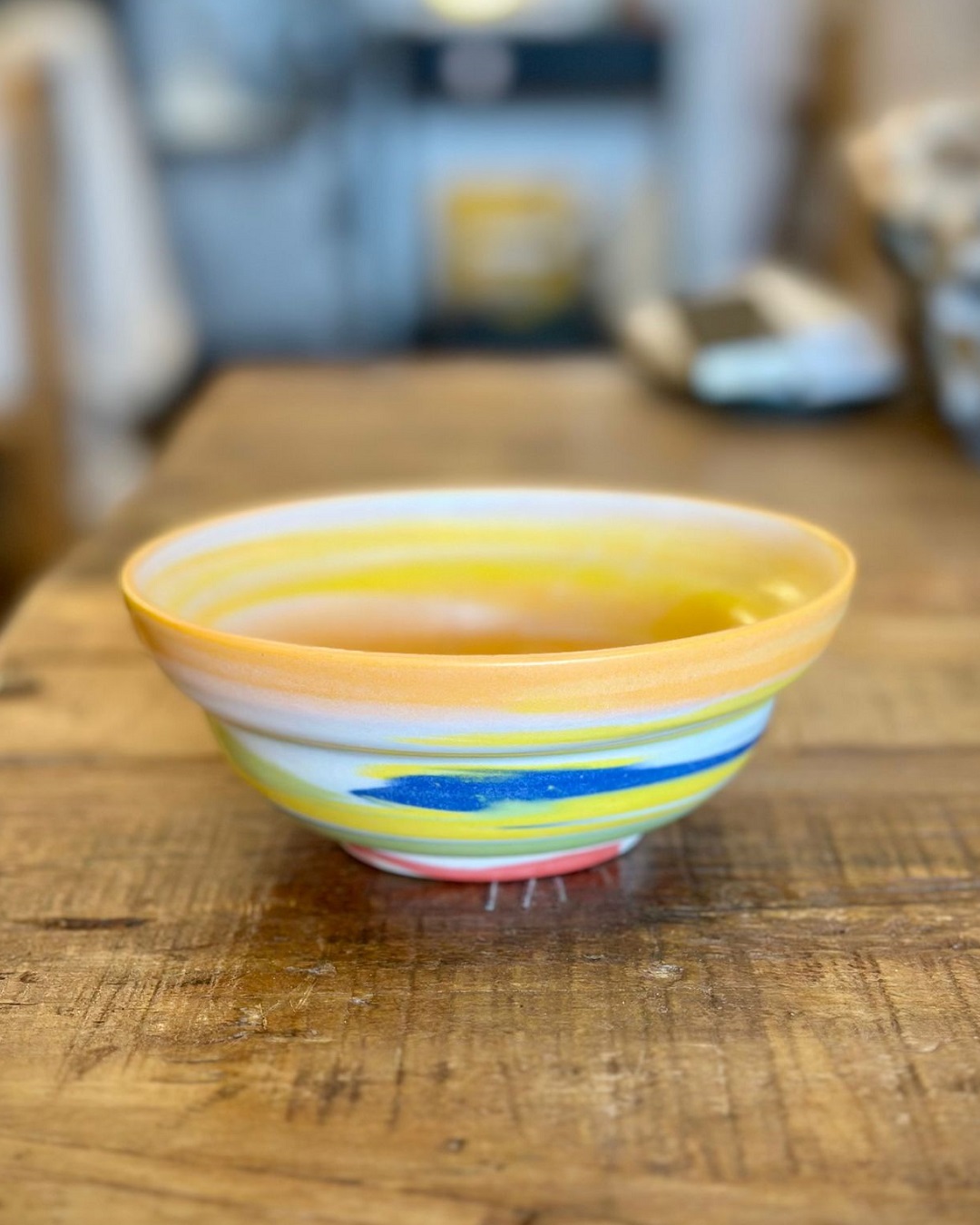 Rainbow ceramic bowl on wooden table