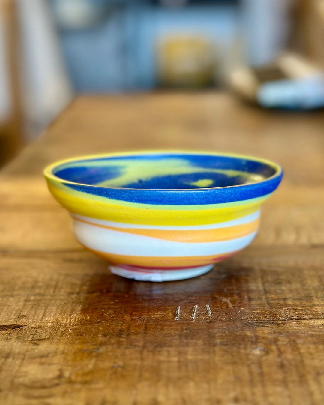 Rainbow ceramic bowl on wooden table