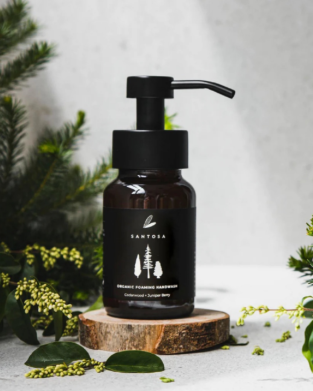 Hand wash pump bottle with cedarwood and juniper berries around it