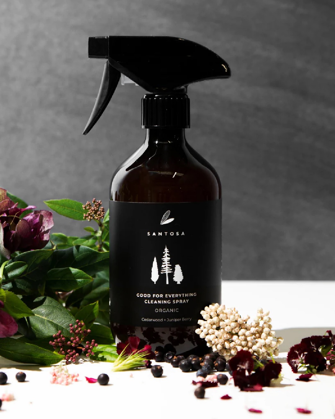 Spray bottle with cedarwood and juniper berries around it