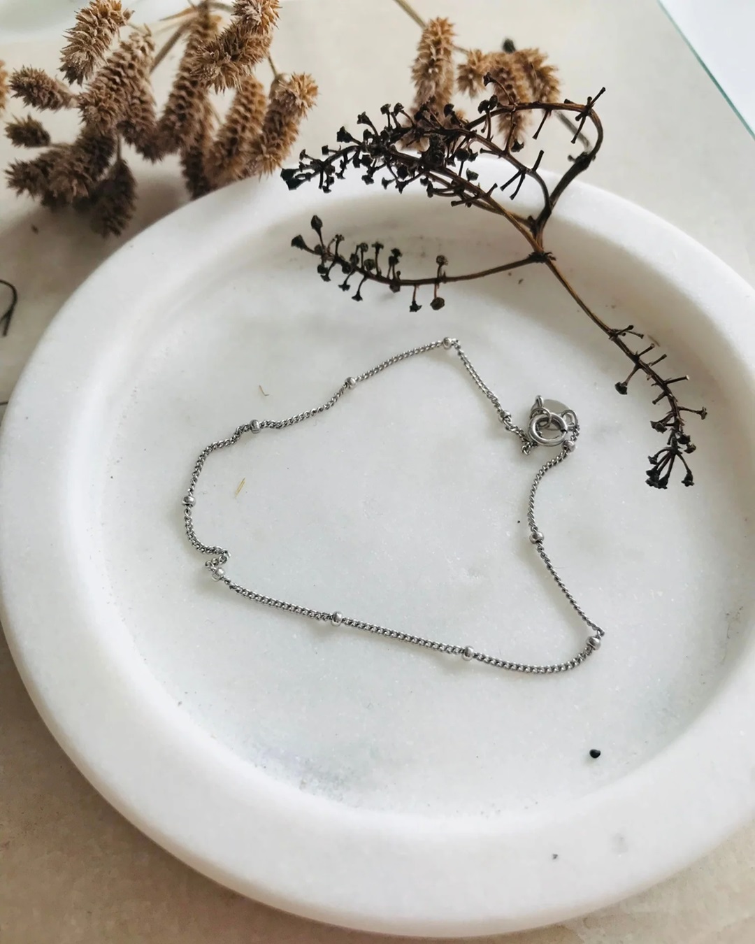 Fine silver chain bracelet on a plate