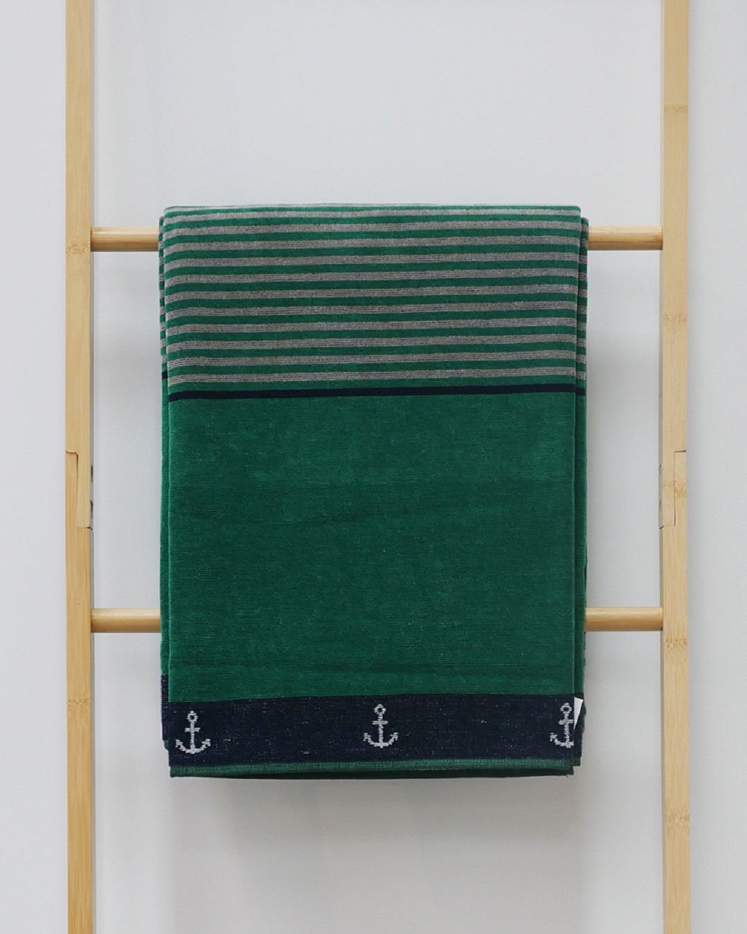 Green and blue beach towel on rack