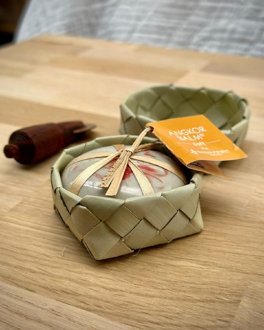 Tiger balm with wooden tool and weaved flax basket on wooden table