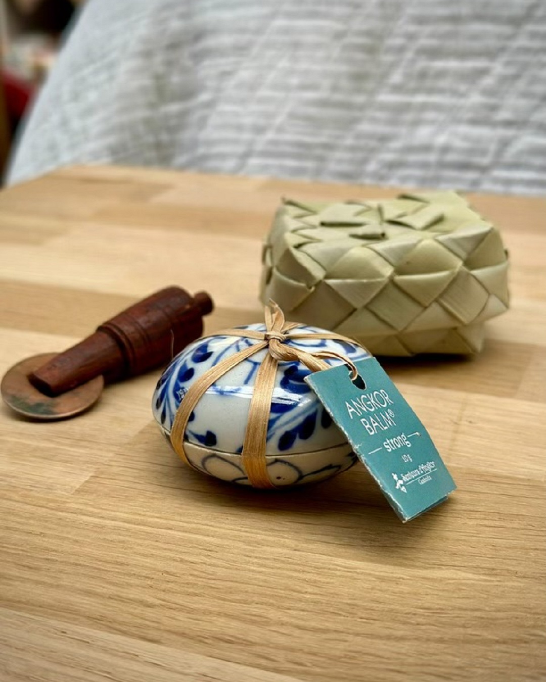 Tiger balm with wooden tool and weaved flax basket on wooden table