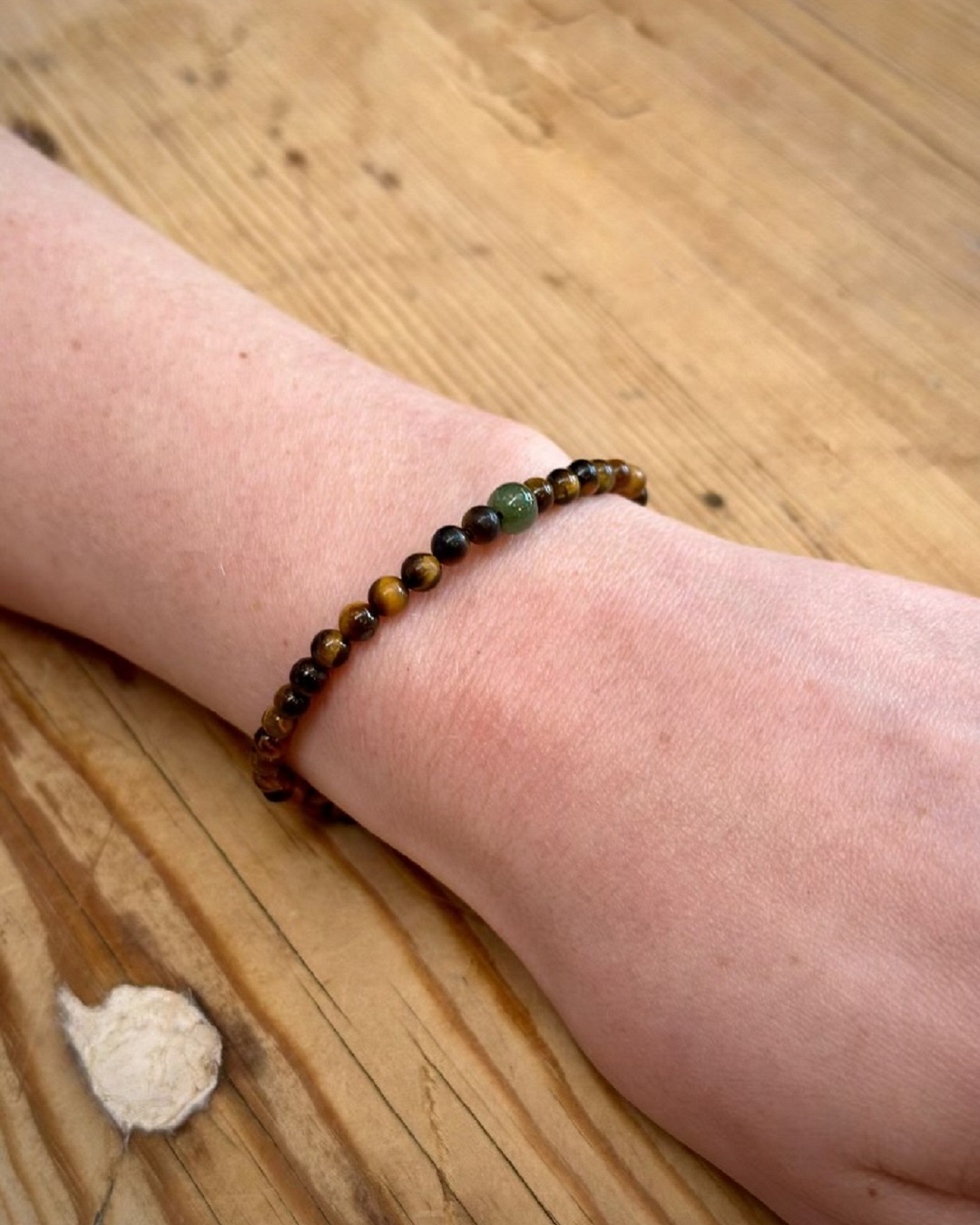 Tigers eye and greenstone gems bracelet on wrist