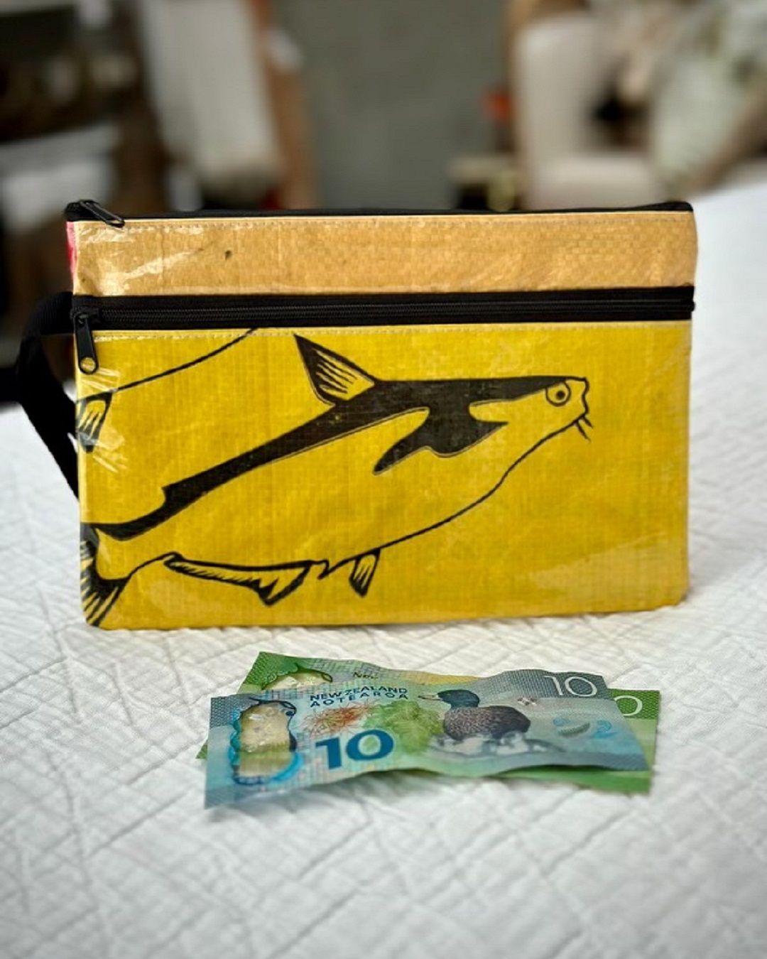 Yellow fish purse on bed